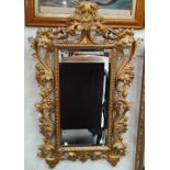 A 19th century highly decorative rectangular bevelled edge wall mirror in carved and gilded