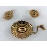A Victorian matching earring and brooch set, oval brooch with patterned front, bobbled edges, safety