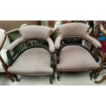 An Edwardian pair of tub shaped ebonised armchairs in brown fabric