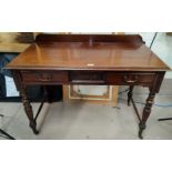 An Edwardian mahogany writing table with 2 frieze drawers, on turned reeded legs and castors, 107 cm