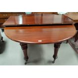 A Victorian dining table with extending oval top, spare leaf, on turned legs and castors, extended