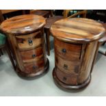 A pair of hardwood circular bedside cabinets on pedestals