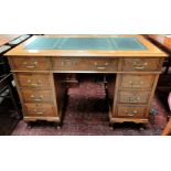 An Edwardian oak kneehole desk with inset leather top and 9 drawers, on cabriole legs, width 117 cm