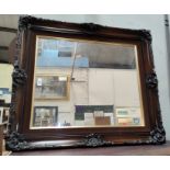 A wood effect rectangular stained mirror with elaborate frame, H: 79cm x W: 69cm