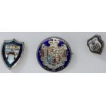 A white metal enamel shield shaped badge, an enamelled Georgian 1835 coin brooch and another badge