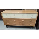 A 1960's G-Plan chest of 4 deep and 6 small drawers in light oak and white laminate, width 150 cm; a