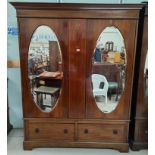 An Edwardian inlaid mahogany double wardrobe in the Sheraton style, part fitted interior with