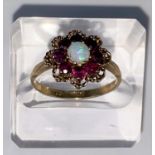 A vintage opal & almondine garnet yellow gold cluster ring, comprising of a central round opal