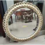 A circular mirror, with pierced cream frame, diameter 63cm.