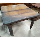 An Edwardian walnut wind out dining table with canted rectangular top, on turned reeded legs and