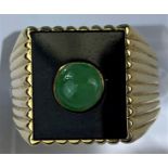 A yellow metal gent's signet ring set with square jet coloured base with central jade coloured domed