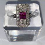 An Art Deco style white metal ruby & diamond ring, comprising of 4 baguette cut rubies surrounded by