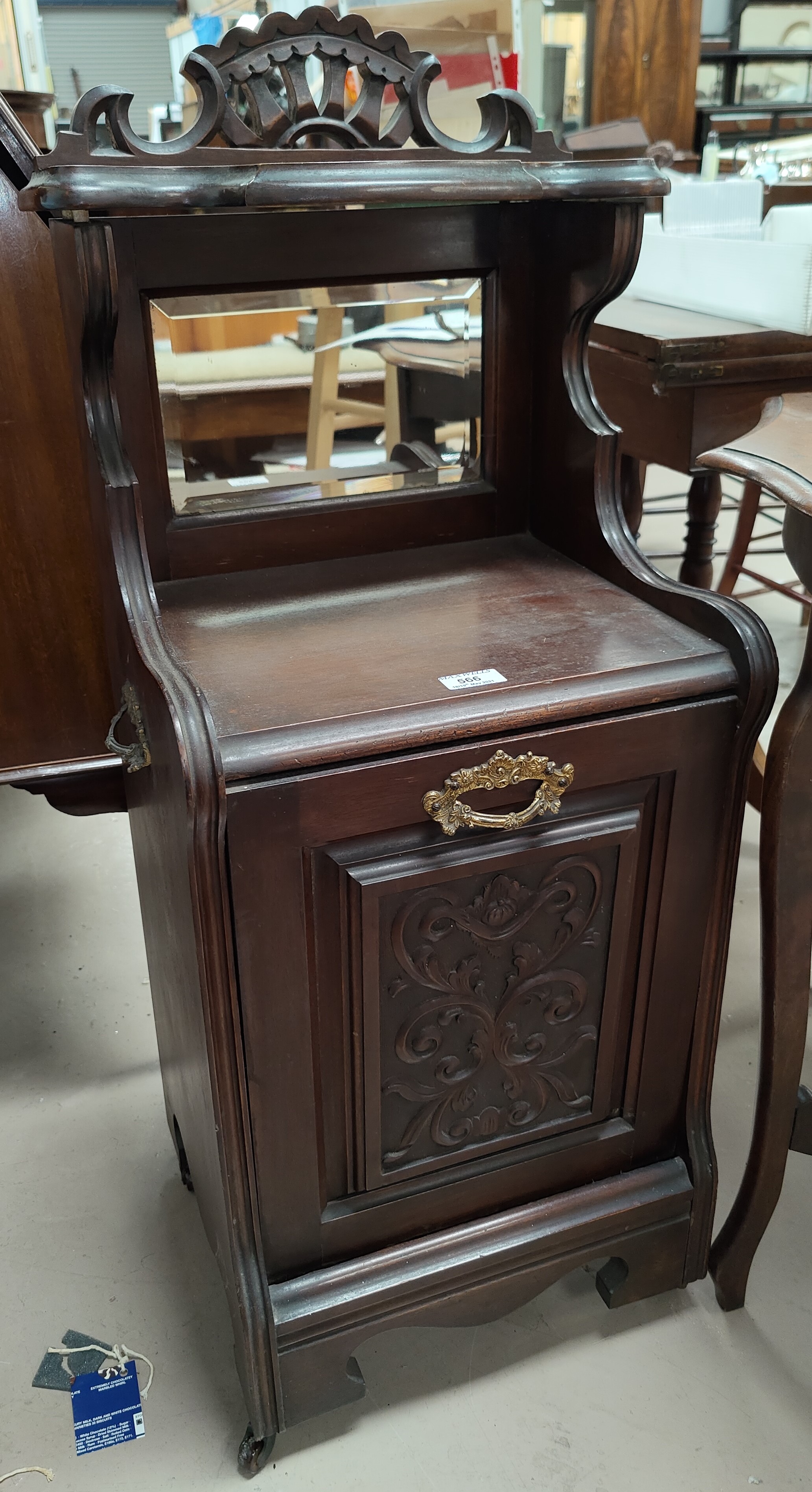 An Edwardian carved mahogany fall front coal box with mirror and shelf over