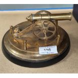 a miniature brass canon on circular stand
