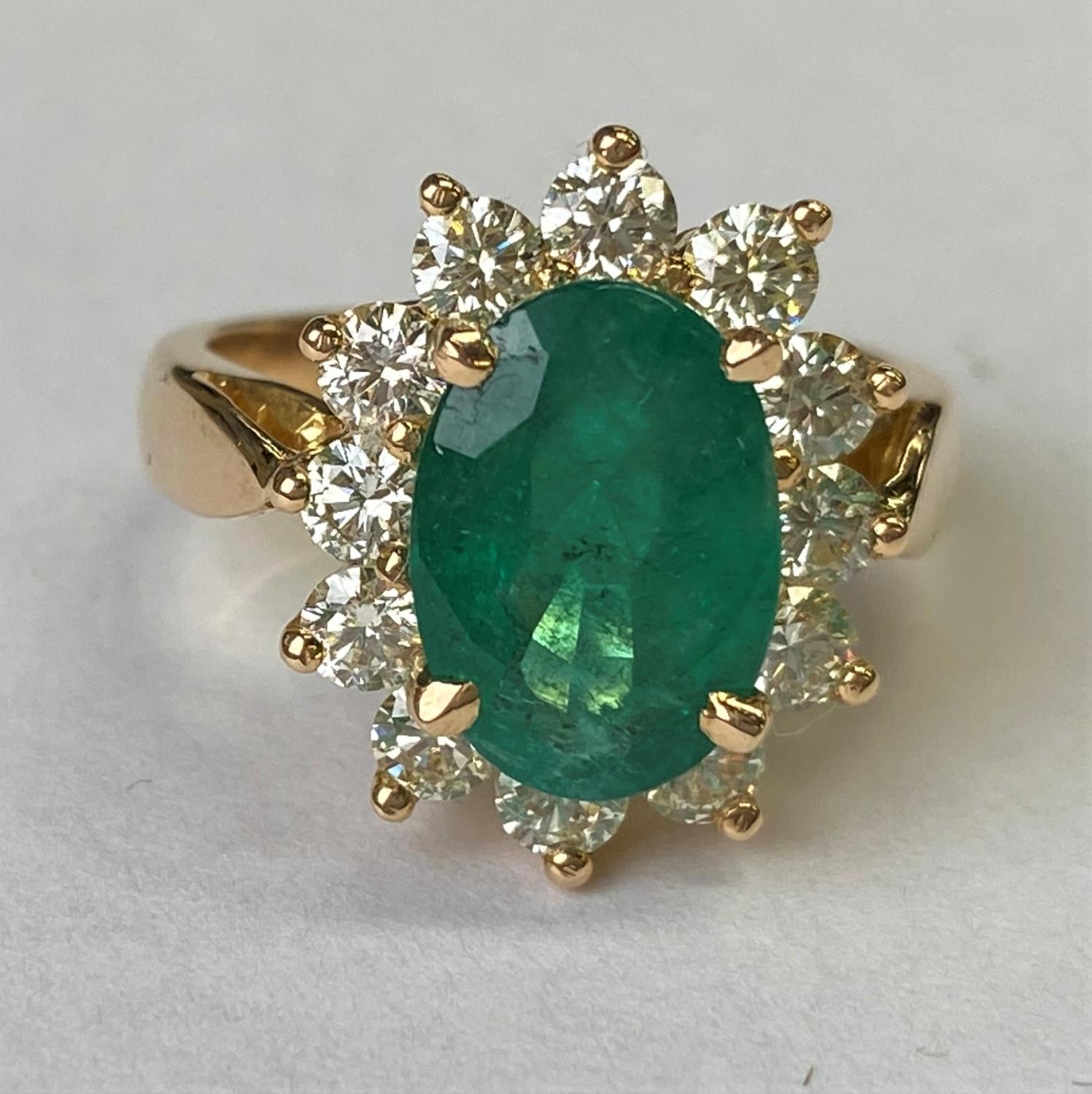 An 18ct gold dress ring set with a large faceted oval emerald, 11mm x 7mm and surrounded by 12 - Image 4 of 4