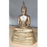 A brass Tibetan Buddha sitting in the Lotus position, with hands clasped, having original prayers (