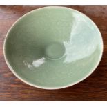 A Chinese celadon glaze dish with incised floral decoration to the interior, diam 22.5cm (3 minor
