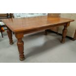 A Golden Oak dining table of rectangular form with rounded edges on heavy turned legs, length