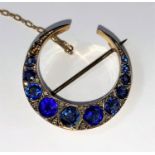 An early 20th century 9ct gold crescent brooch sapphire and other stones (replacements) interspersed