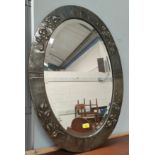 An oval wall mirror in Art Nouveau anodised embossed frame