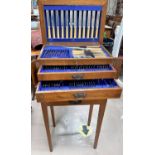 An Oak canteen on stand of silver plated cutlery with hinged lid, drawers below