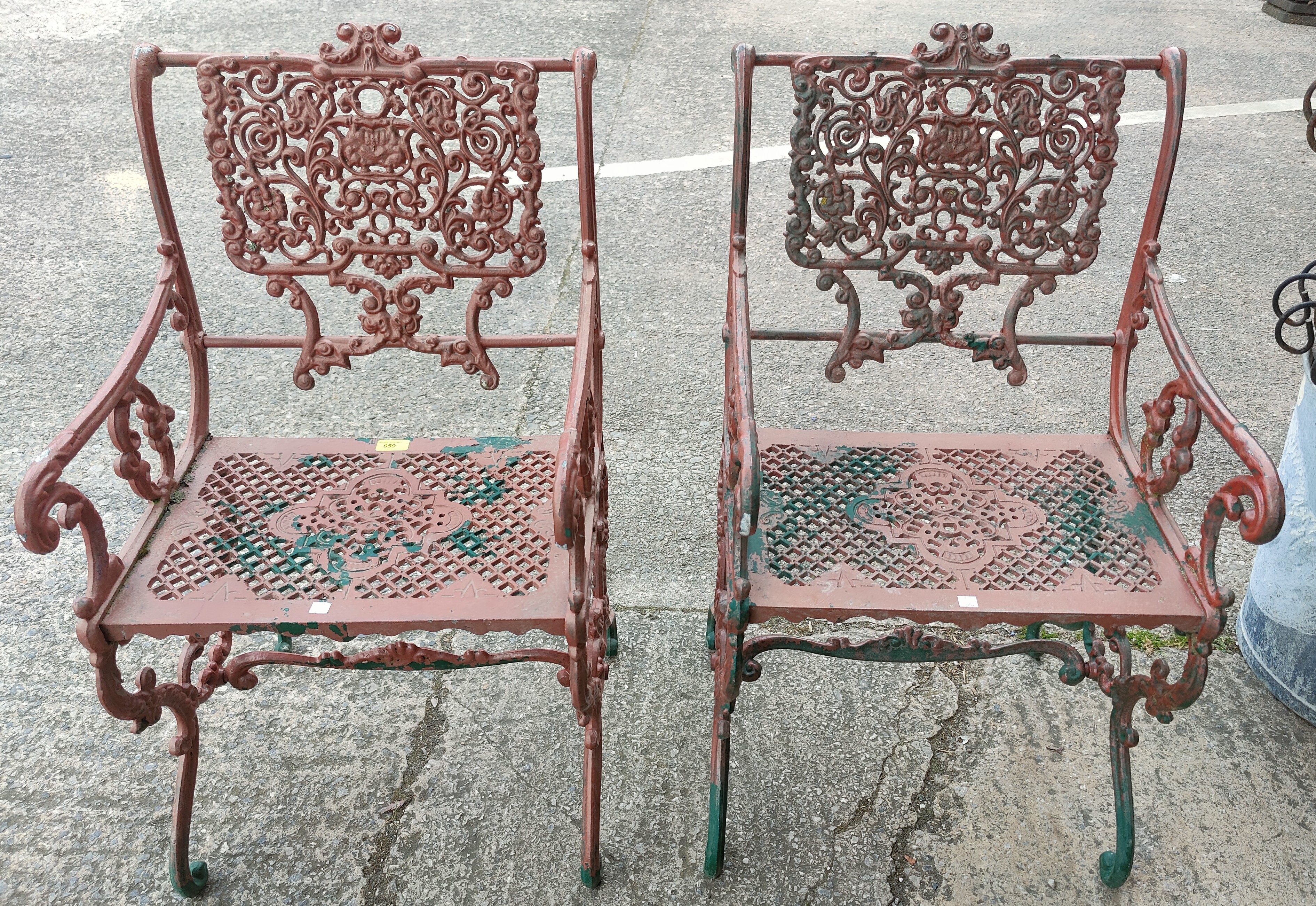 A pair of Victorian style unusual cast metal garden arm chairs