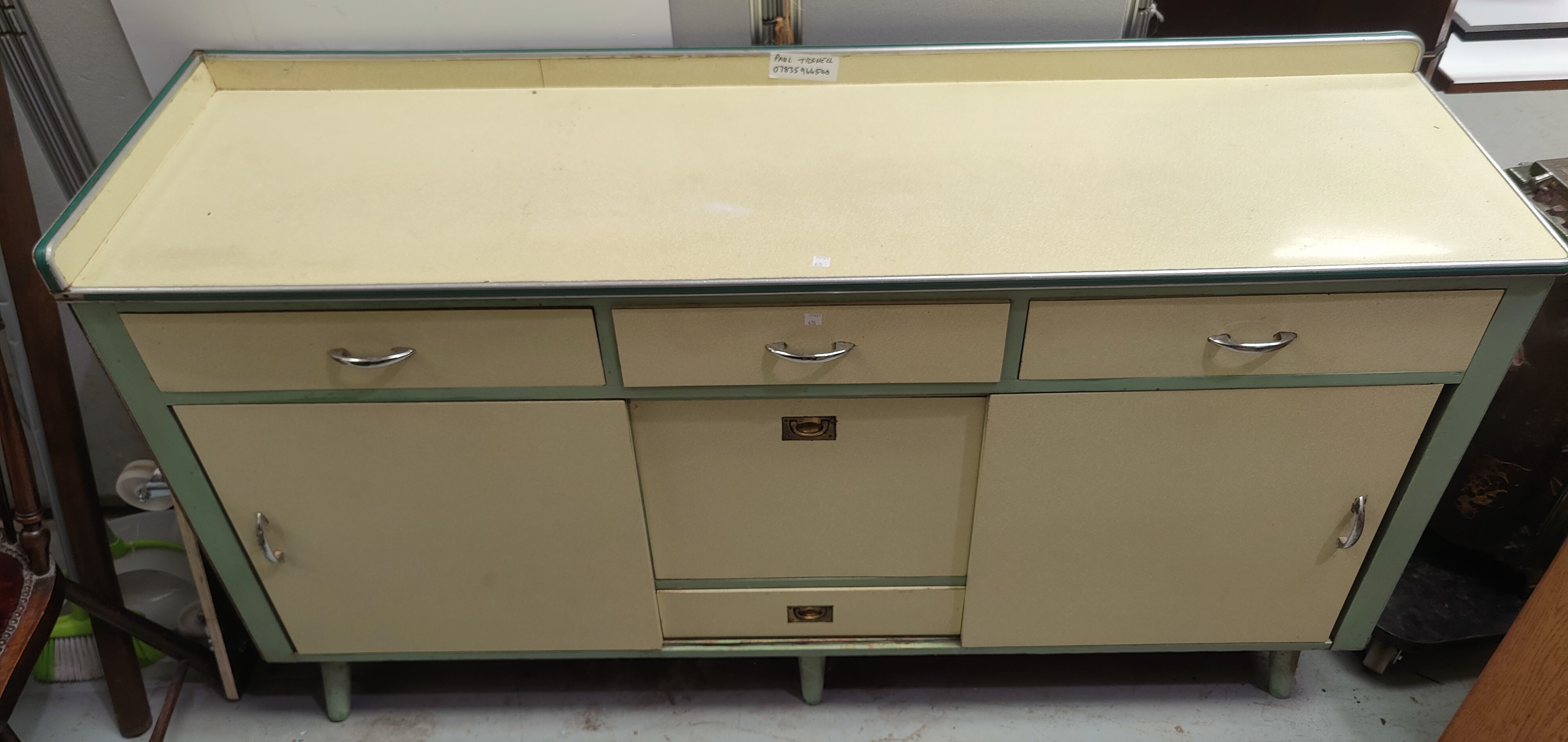 A 1950's Formica kitchen base unit in yellow with 3 frieze drawers, 2 side cupboards and central