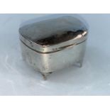 A rounded rectangular silver trinket box with hinged lid, four feet and weighted base, Birmingham