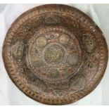 A Tibetan copper and brass charger with relief decoration of buddhas etc, diameter 38cm