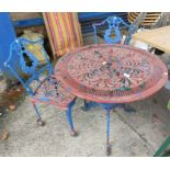 A Victorian style cast metal circular garden table and two chairs
