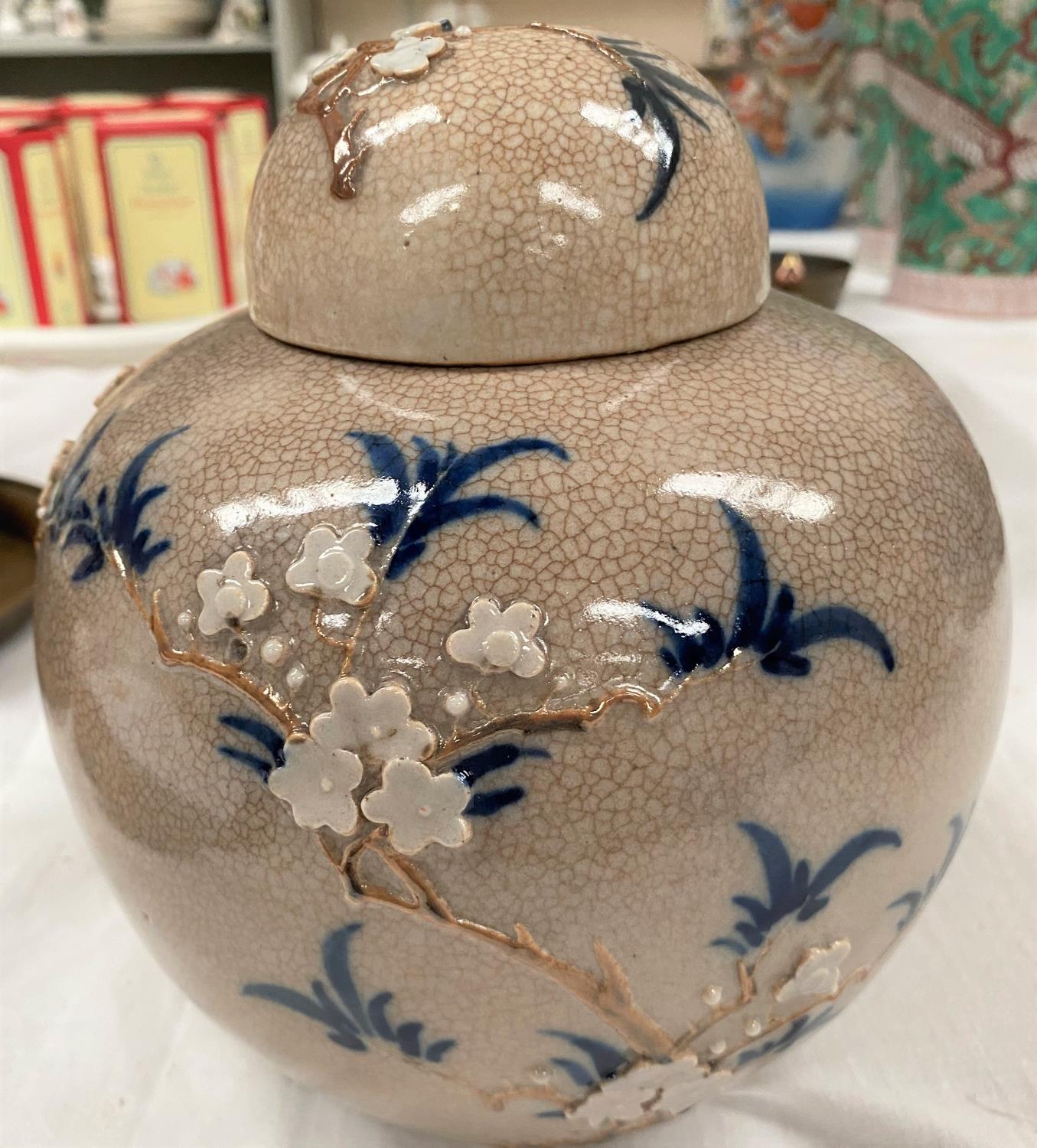 A Chinese crackle glaze lidded ginger jar with applied decoration of tree branches with flowers,