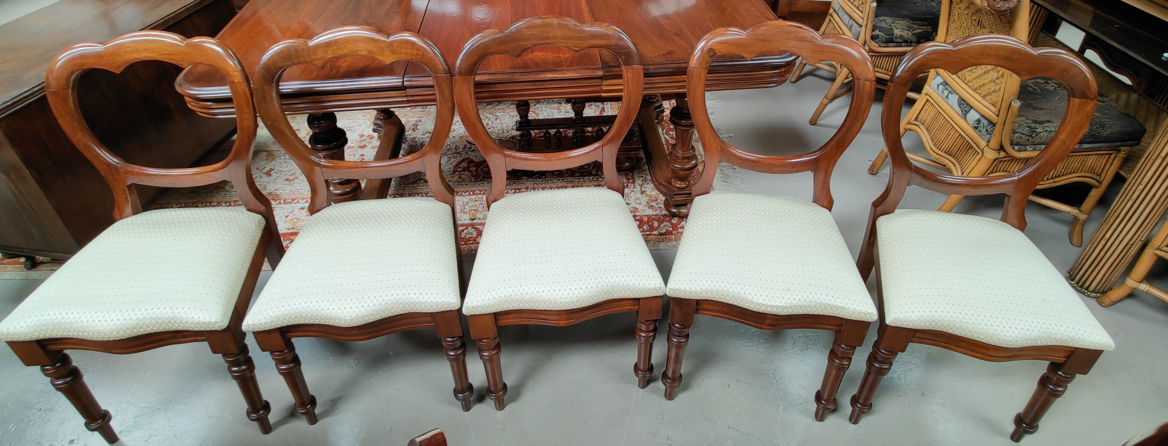 A Victorian set of 6 mahogany dining chairs with balloon backs reupholstered in patterned cream