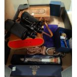 A brown leather suitcase; a pair of binoculars; a cased balance scale; etc.