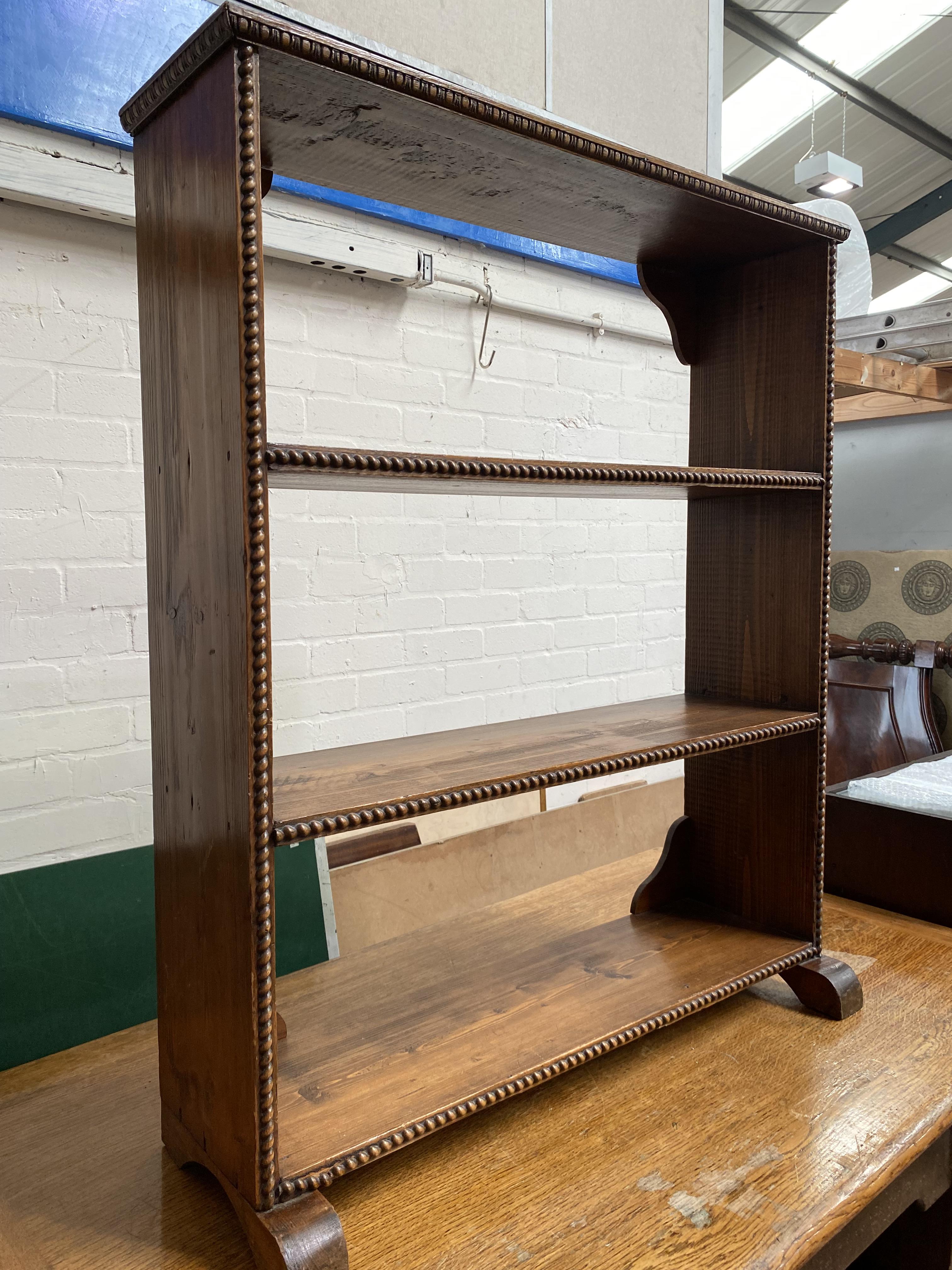 A 3 height bookcase in beaded pine; a standard lamp in turned and carved mahogany