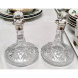 A pair of small cut glass liquor decanters with hallmarked silver collars. Height 16cm.