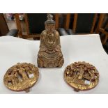 A Chinese carved wood gilt figure of a seated buddha and 2 Chinese circular carved wood wall plaques