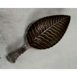 A Georgian hallmarked silver caddy spoon, the bowl in the form of a leaf with monogram to the