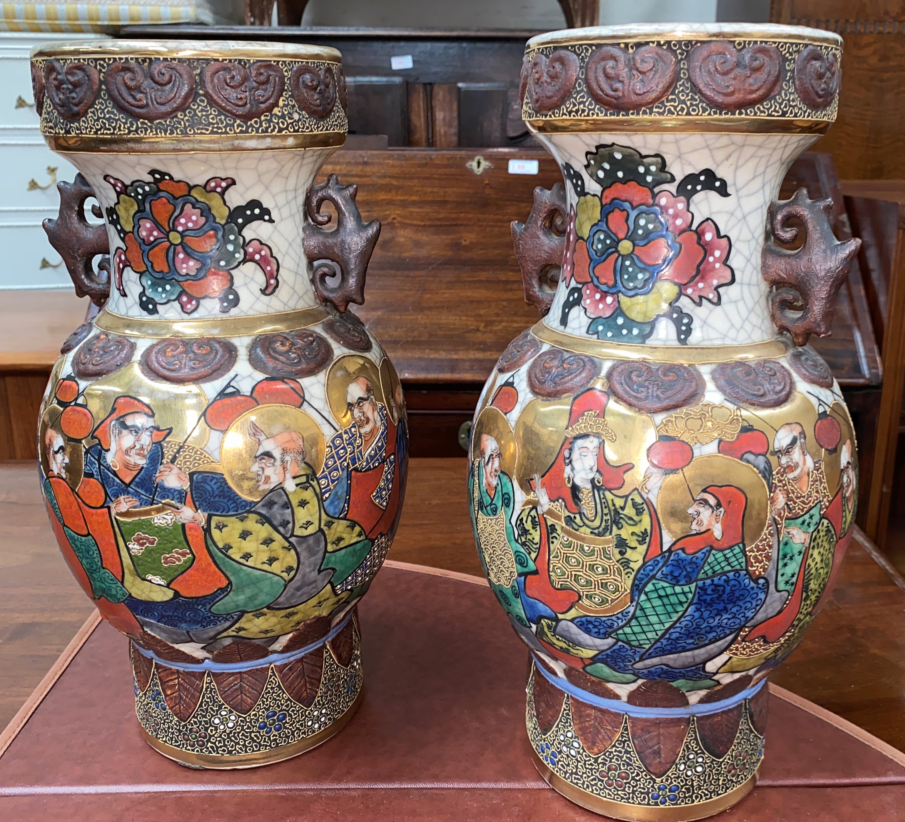 A pair of oriental crackle glaze vases decorated with men with gilt haloes holding lanterns,