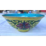 A Chinese yellow glaze bowl with detailed leaves connecting three red flowers, with turquoise