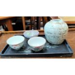 Two Chinese tea bowls, one with red bamboo panels, another with a traditional scene, both with