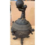 A Japanese bronze lidded pot on three dragon head feet, the lid with child holding large ball,