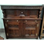 An early 20th century oak court cupboard with blind fret decoration, 2 drawers and 2 cupboards under