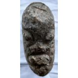 An African carved stone head, eyes, mouth and nose in relief 18cm