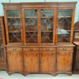 A reproduction yew wood library bookcase with breakfront, 4 astragal glazed door over 4 drawers