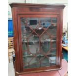 A 19th century mahogany corner cupboard enclosed by single astragal glazed door