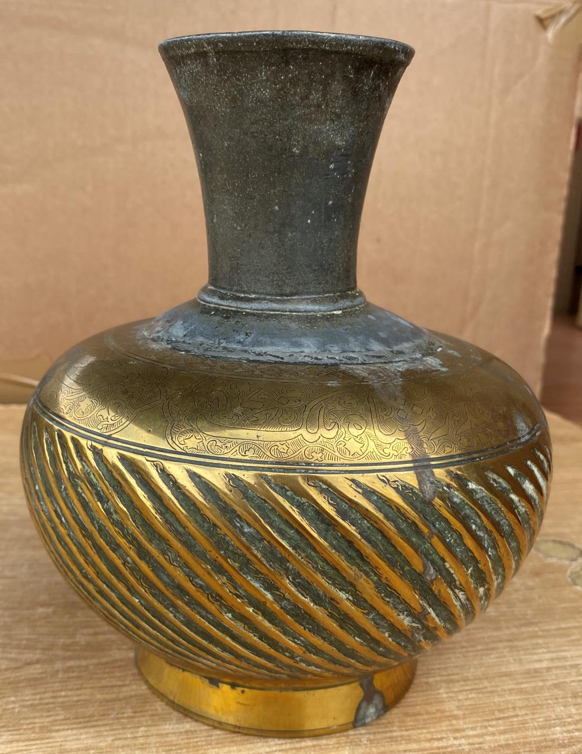 An Indo-Persian mixed metal vase with ribbed decoartion and text above, height 19.5cm