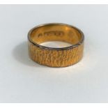 A 22 carat hallmarked gold wide wedding ring with bark effect, 8.9 gm