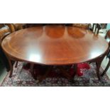 A mahogany Regency style dining table with multiple satinwood crossbanding, circular top, on