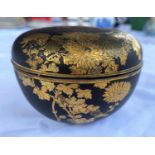 A Japanese Meiji period gilt and matt black metal lidded pot with finely detailed decoration of