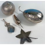 A white metal trinket box in the form of a fruit with relief decoration and star shaped leaf (